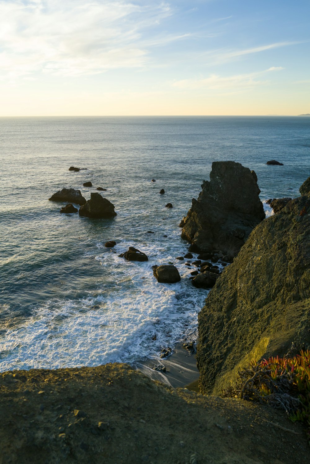 a view of the ocean from the top of a hill