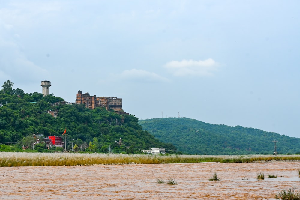 a castle sits on a hill above a river