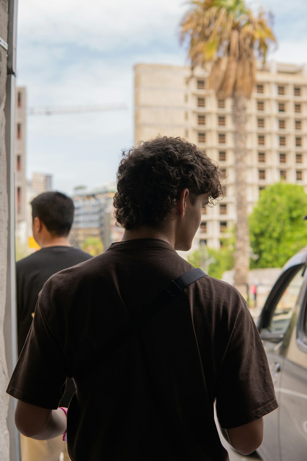 Un uomo in piedi accanto a un'auto parcheggiata