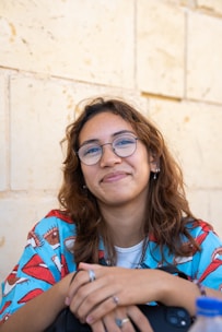 a woman wearing glasses sitting at a table