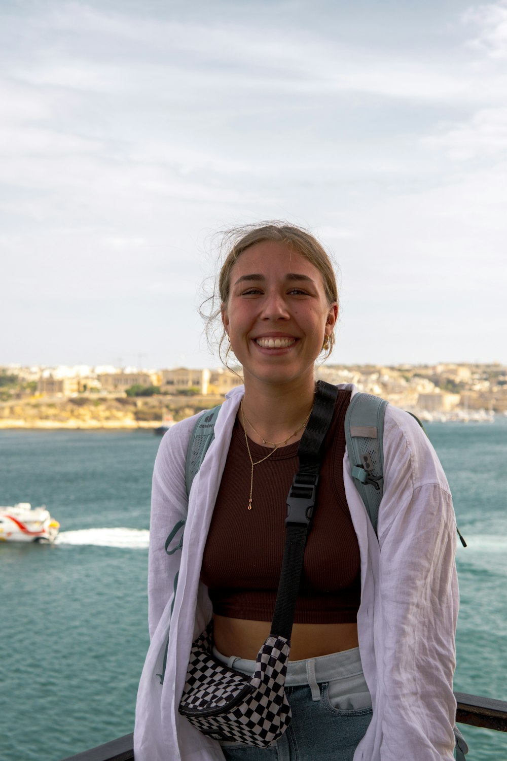 a woman standing on a bridge next to a body of water