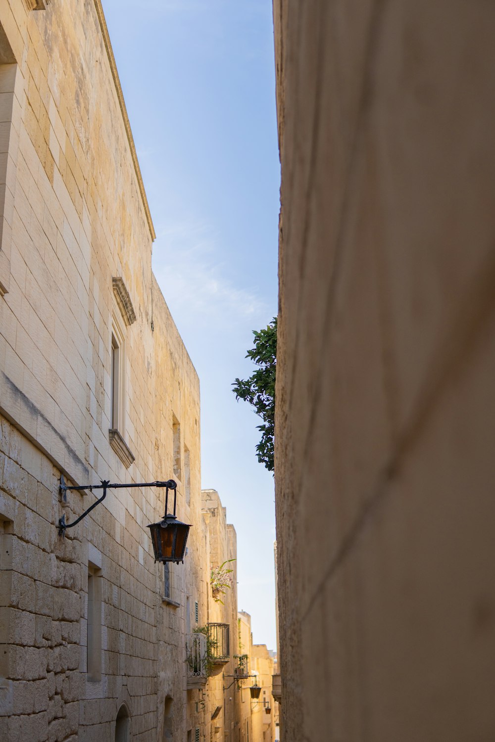 a narrow alley way with a lamp on the side