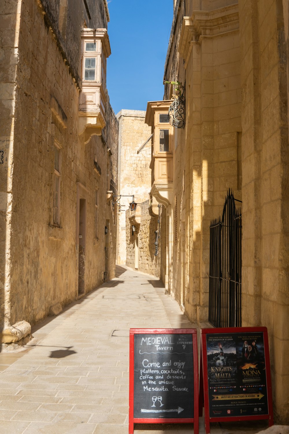 a narrow street with a sign on the side of it