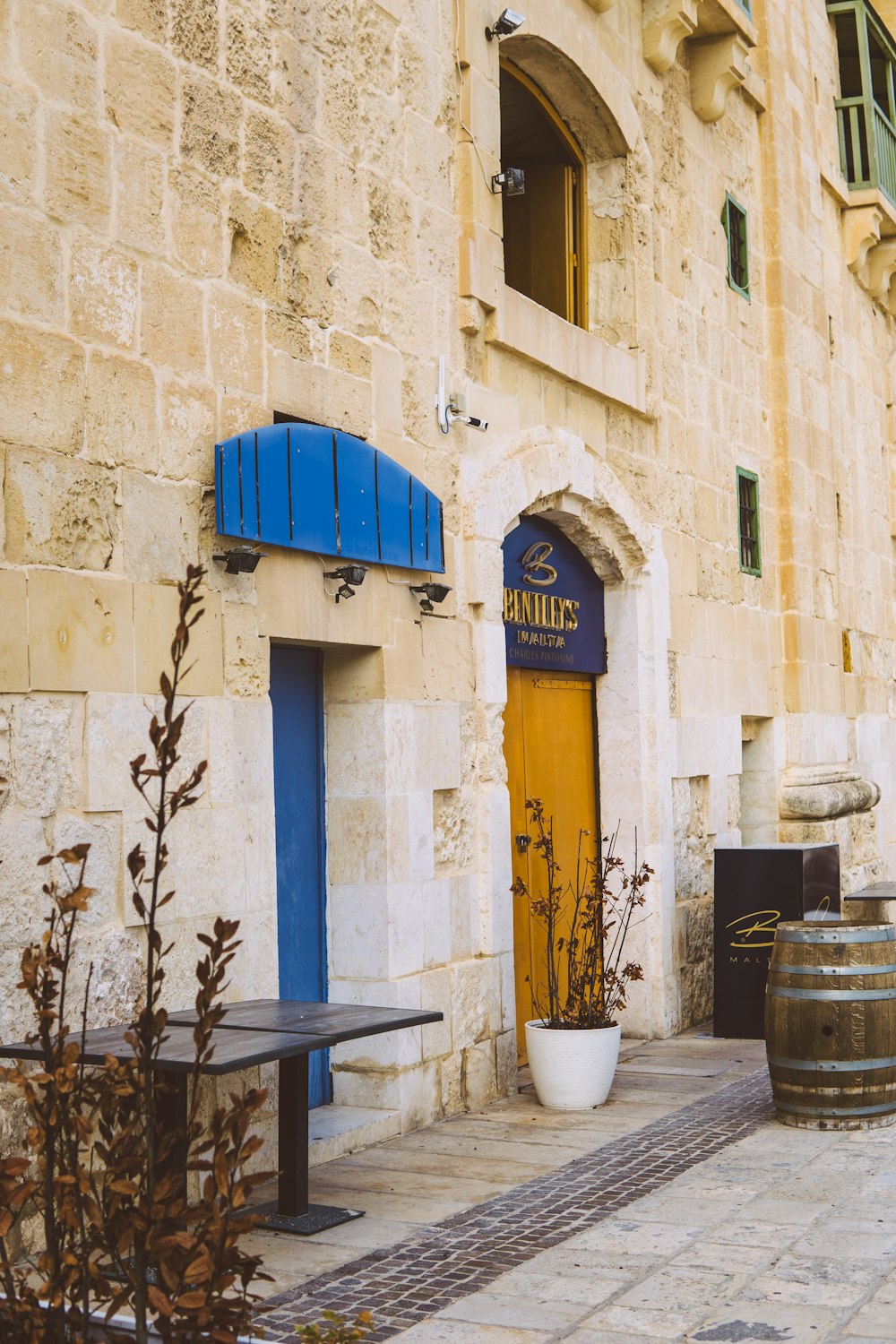 a building with a yellow door and blue shutters