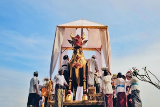 a group of people standing around a statue of a bull