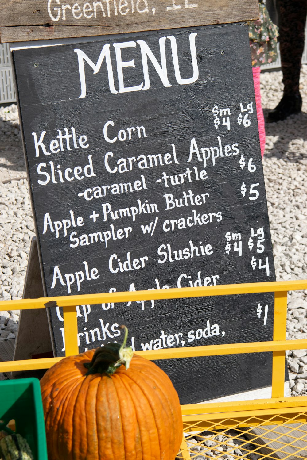a menu board with a pumpkin sitting on top of it