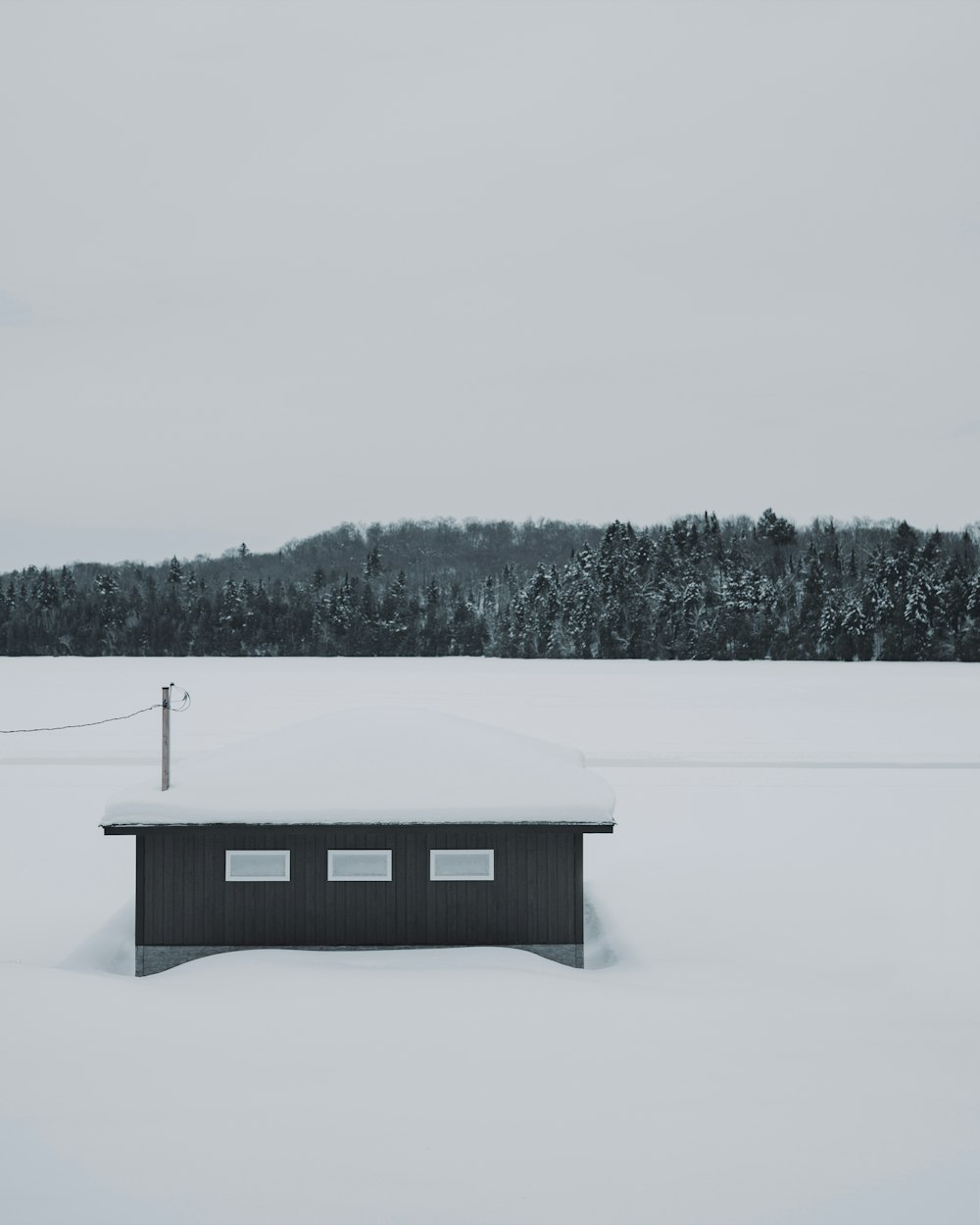 a bench sitting in the middle of a snow covered field