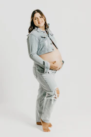A smiling nutritionist consulting with a pregnant woman, pointing to a healthy meal plan on a tablet.