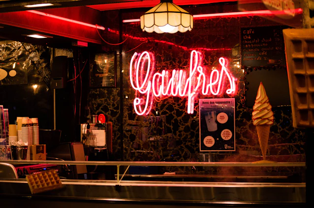 A cozy waffle shop interior with warm lighting and a display of freshly made waffles.