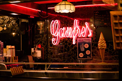 The cozy interior of wafflelab with warm lighting and happy guests enjoying their dessert creations.