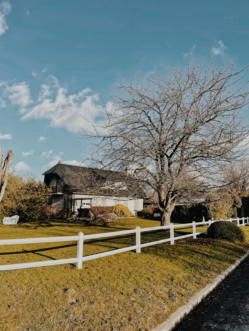 a white fence is in front of a house