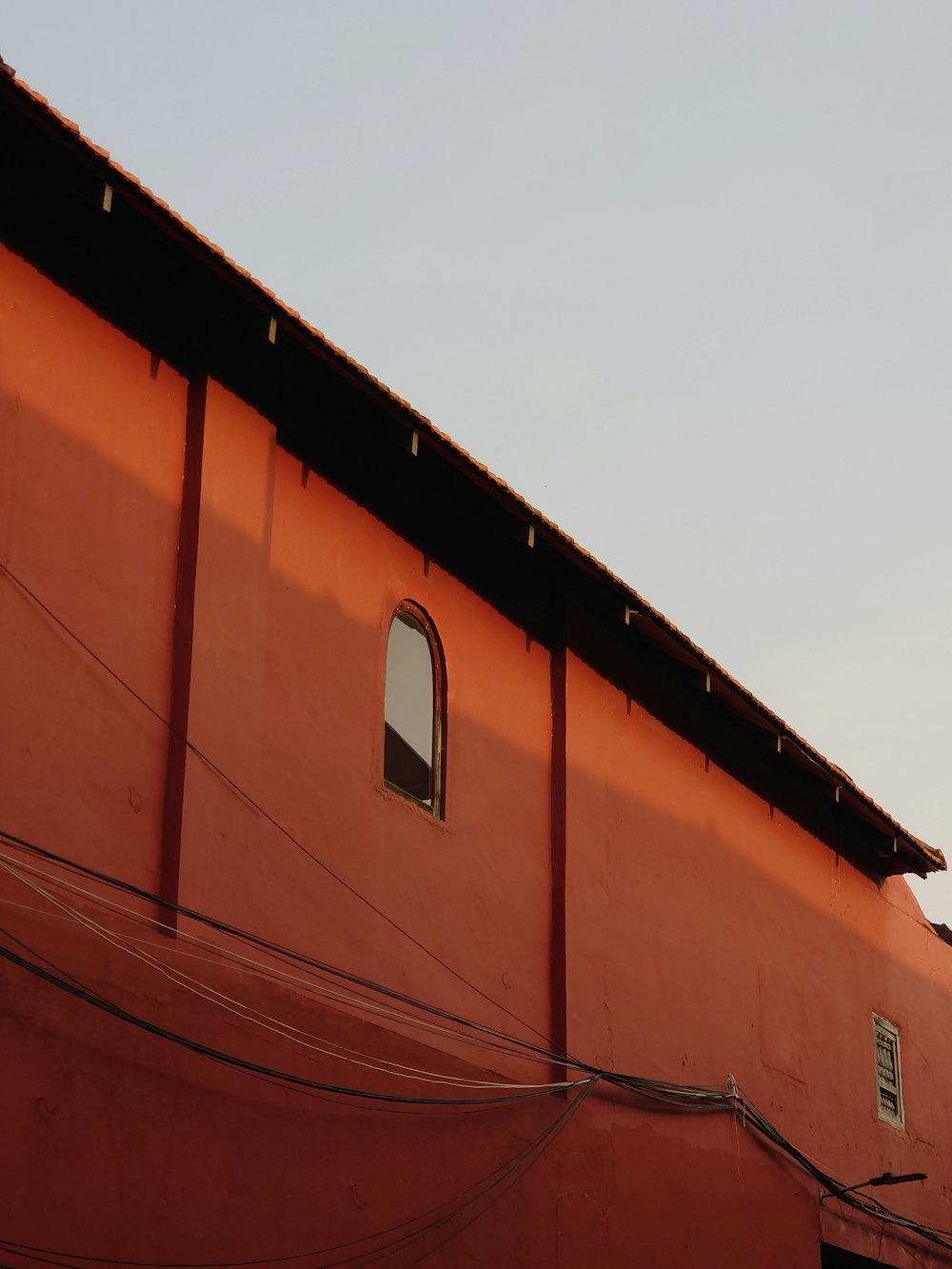 a red building with a clock on the side of it