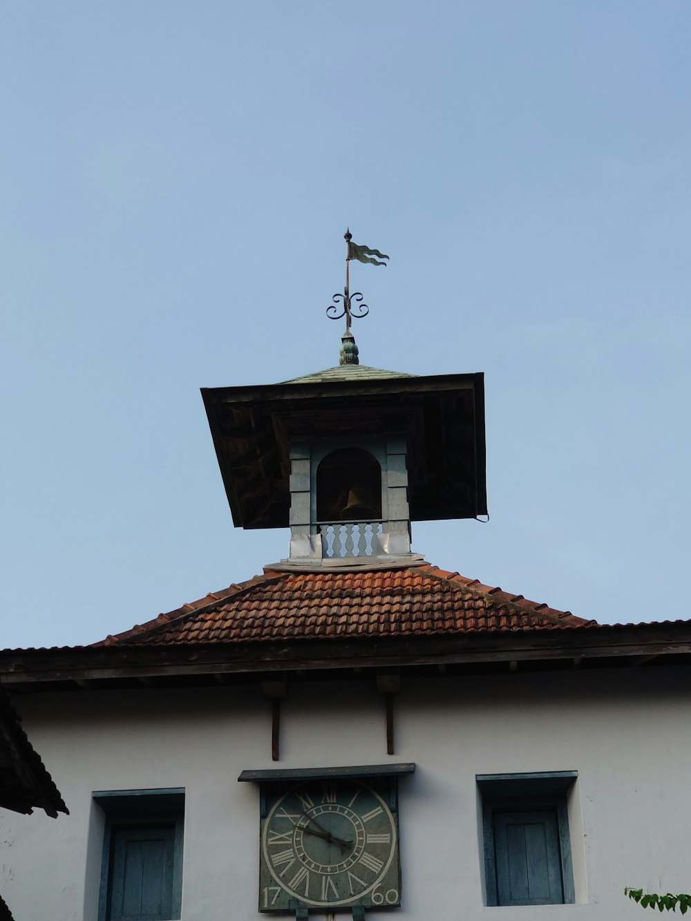 a clock tower with a weather vane on top of it