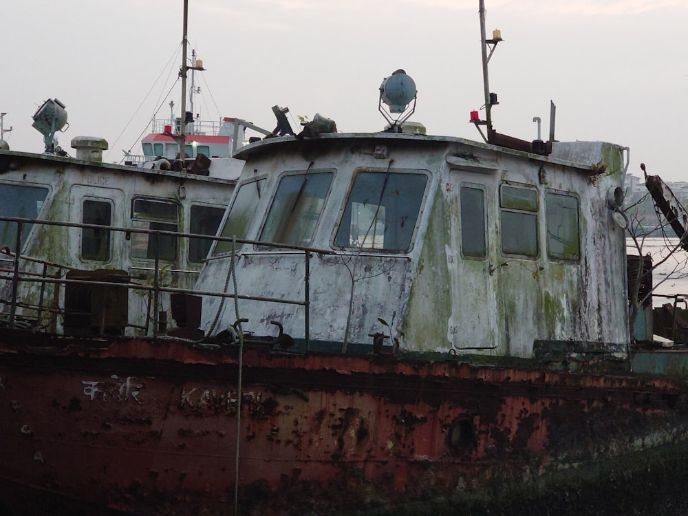 a rusted boat sitting on top of a body of water