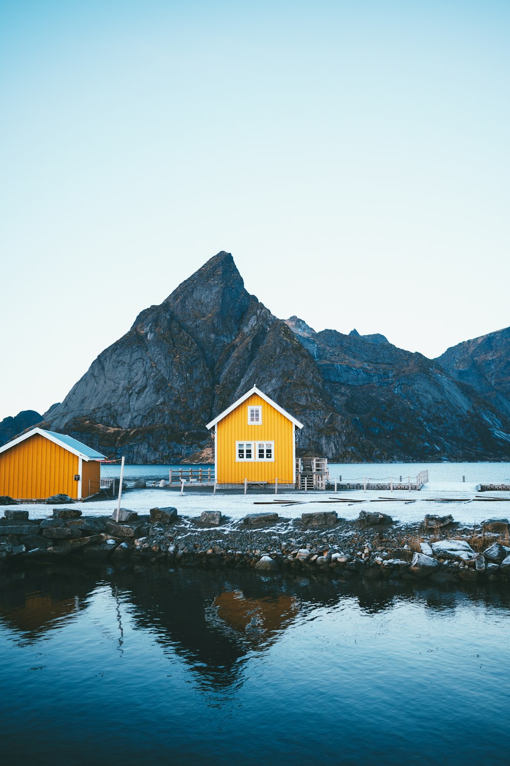 a couple of yellow buildings sitting next to a mountain