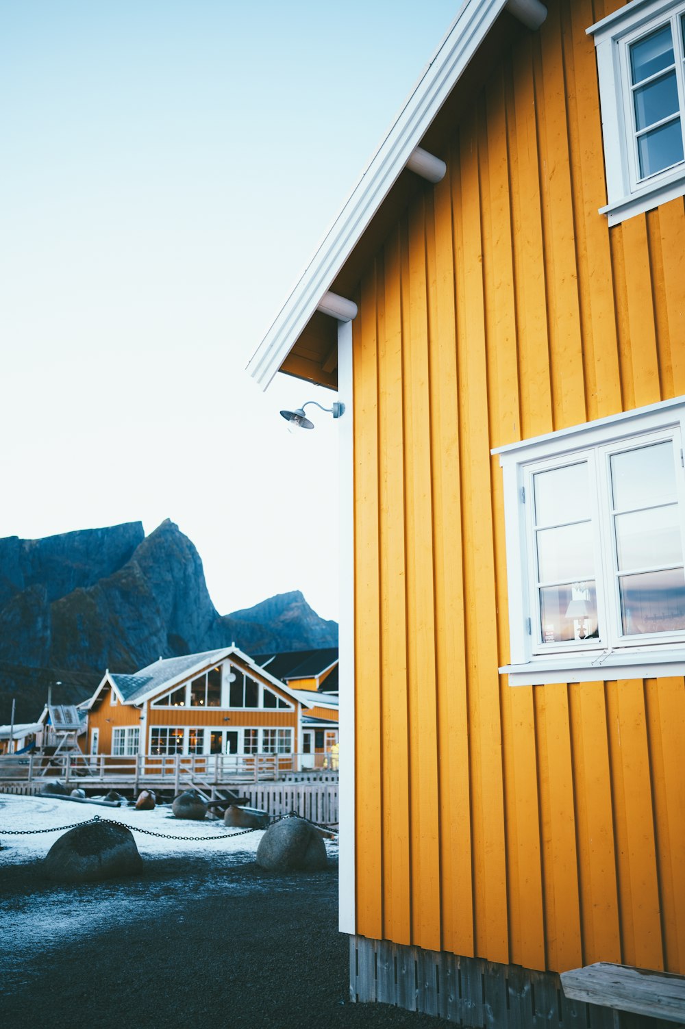 a yellow building with a mountain in the background