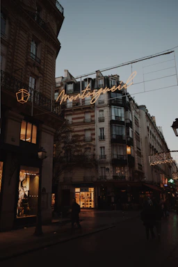 A serene Parisian street at dusk with soft glowing lights reflecting a calm and inviting atmosphere.