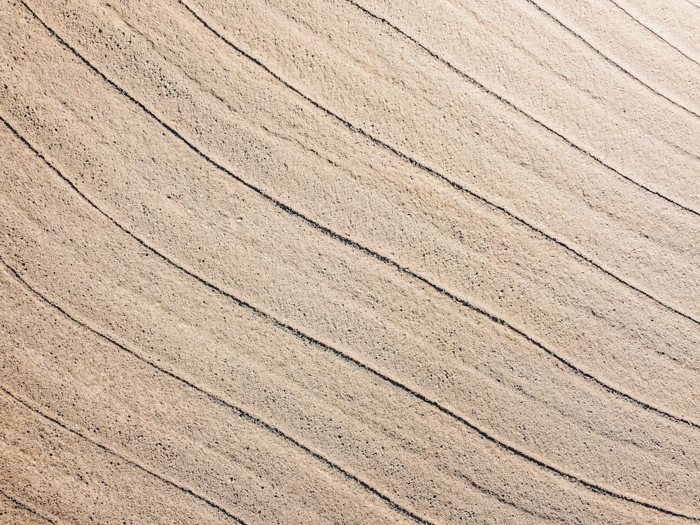 a person riding a surfboard on top of a sandy beach