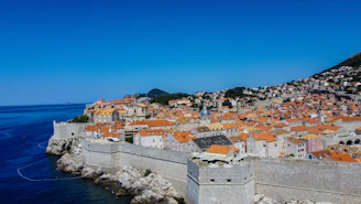 Panoramic view of Zadar’s old town rooftops with the shimmering sea beyond at sunrise.