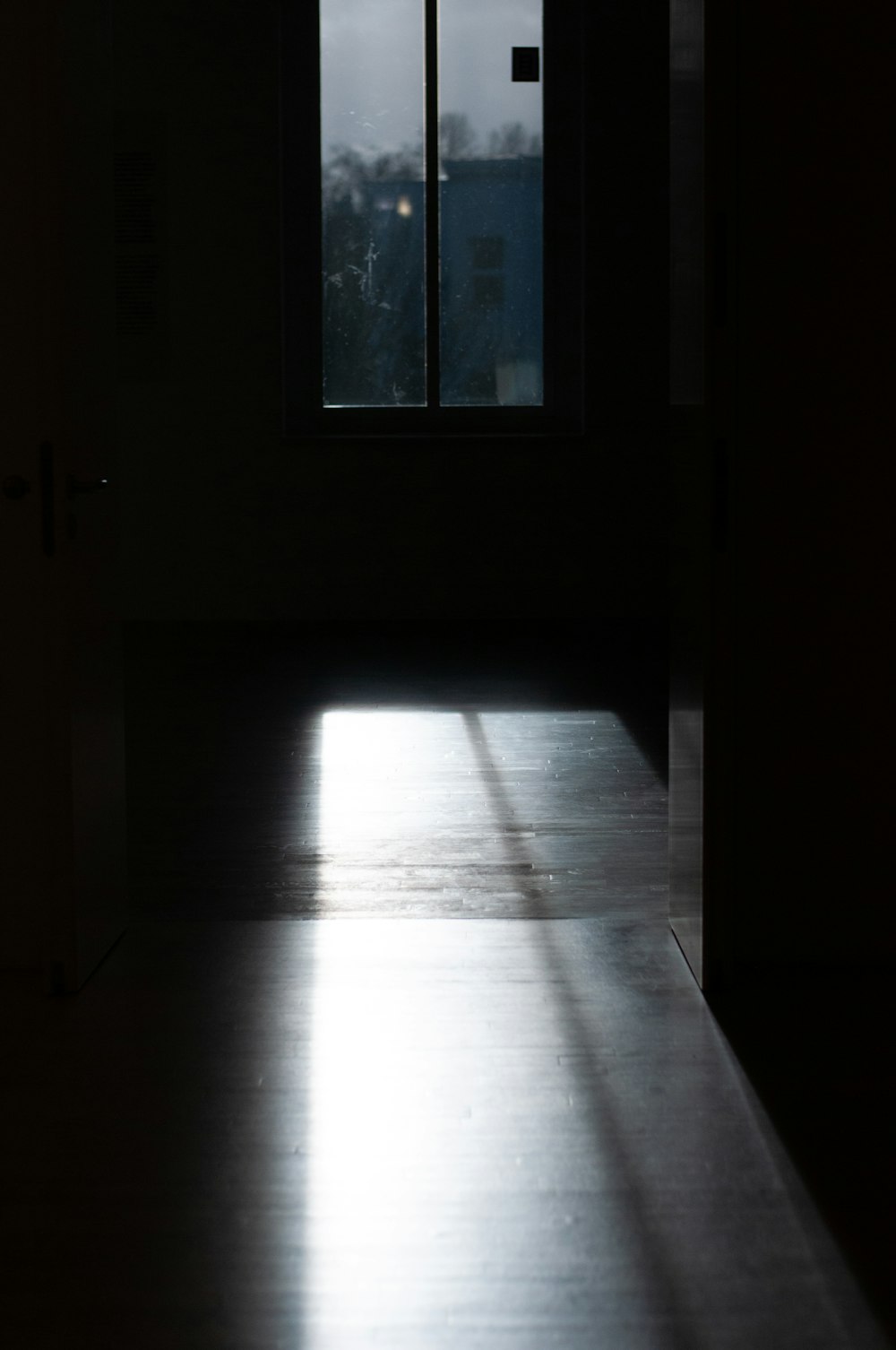 a dark room with a door and a window
