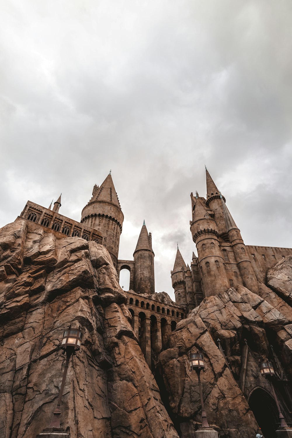 a castle made of rocks with a cloudy sky in the background