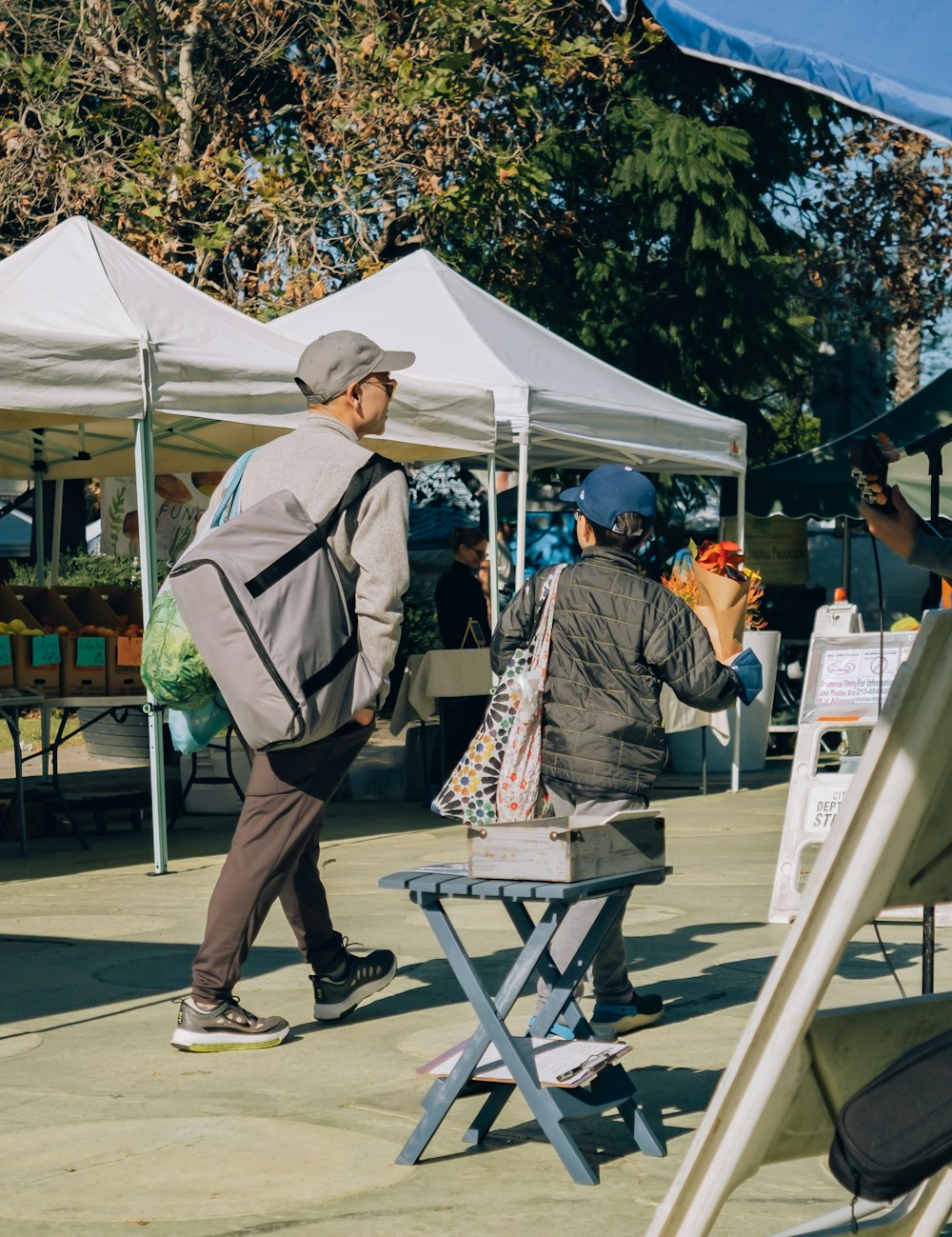 a man standing next to a table with a bag on it