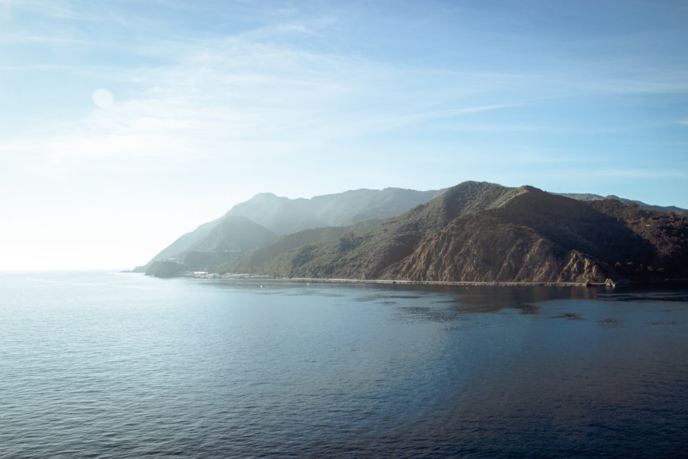 a large body of water with mountains in the background