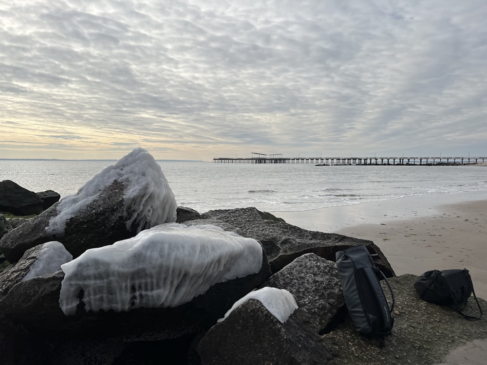 a beach covered in snow next to a body of water