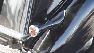 Close-up of a sleek car’s surface reflecting sunlight after detailing.