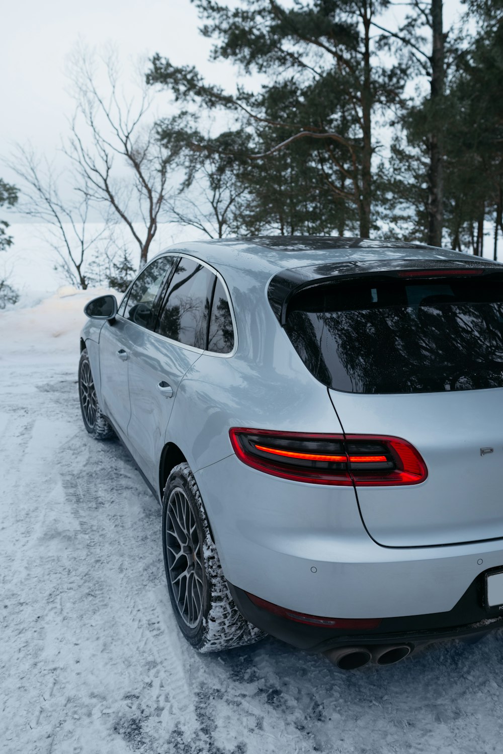 a silver car parked on a snowy road