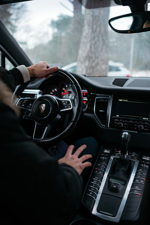 A friendly driving instructor helping a student in a modern car.