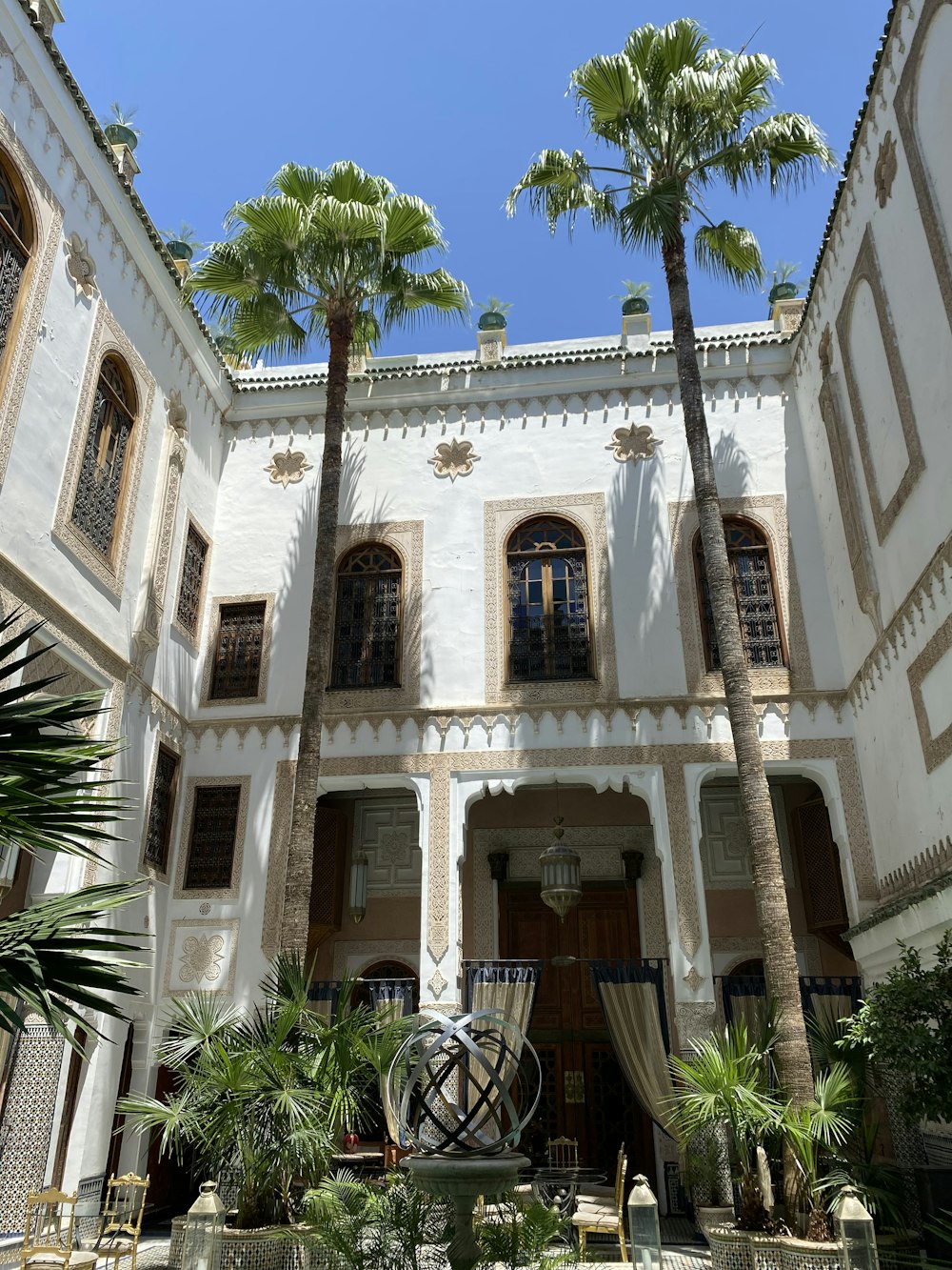 a courtyard with a fountain and palm trees