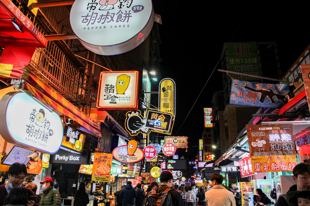 a group of people walking down a street at night