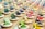An array of colorful herbal powders in small bowls against a rustic backdrop.