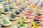 An array of colorful herbal powders in small bowls against a rustic backdrop.