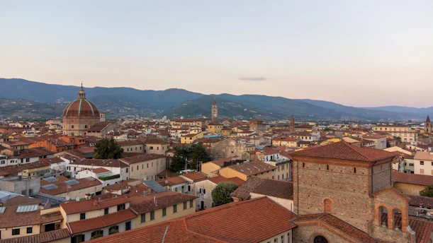 Italian flag waving gently over historic domes at sunset