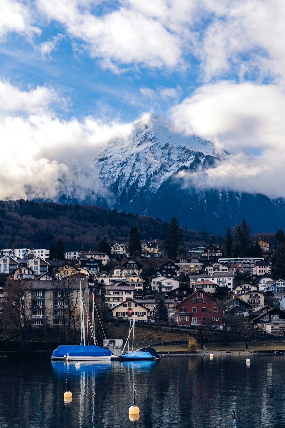 a blue boat floating on top of a lake next to a mountain