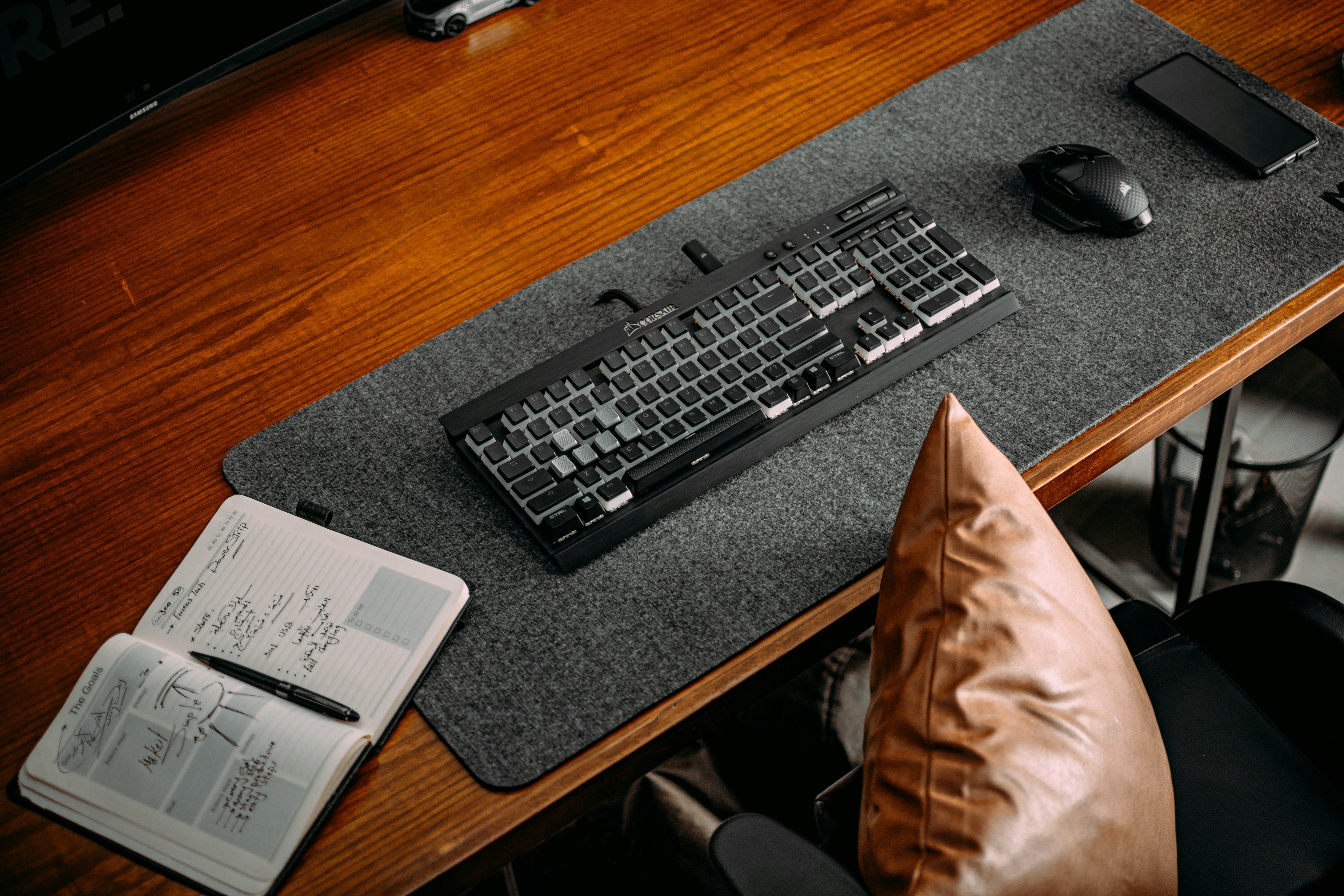 a desk with a keyboard, mouse and pad on it
