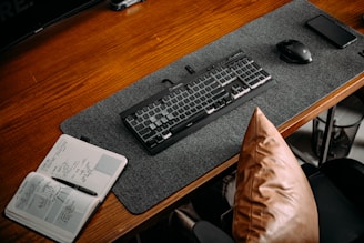 A professional workspace with a laptop and a notebook on a wooden desk.