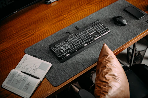 A cozy workspace with a laptop, sketches, and design notes scattered on a wooden desk.