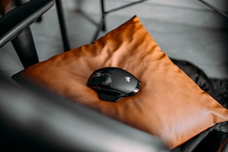 Vintage mechanical mouse resting on colorful fabric.