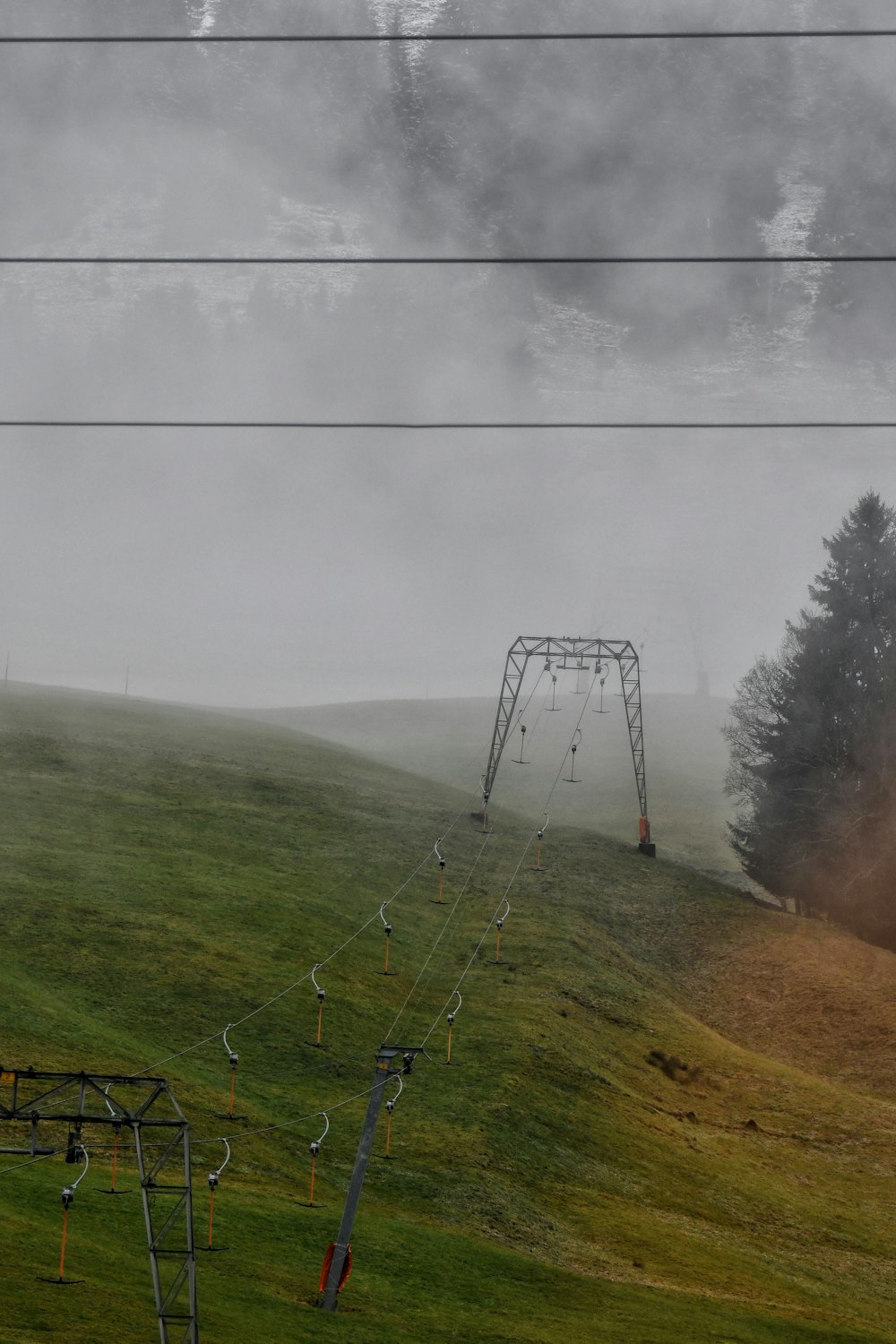 a view of a foggy field with a ski lift in the distance