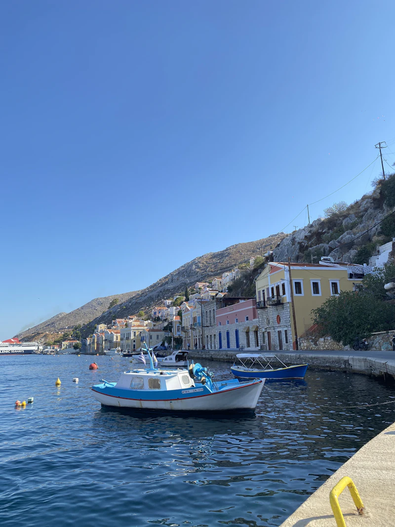 Boats moored below neoclassical houses climbing the hillside