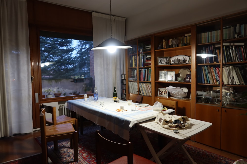 a dining room with a table, chairs, and bookshelves