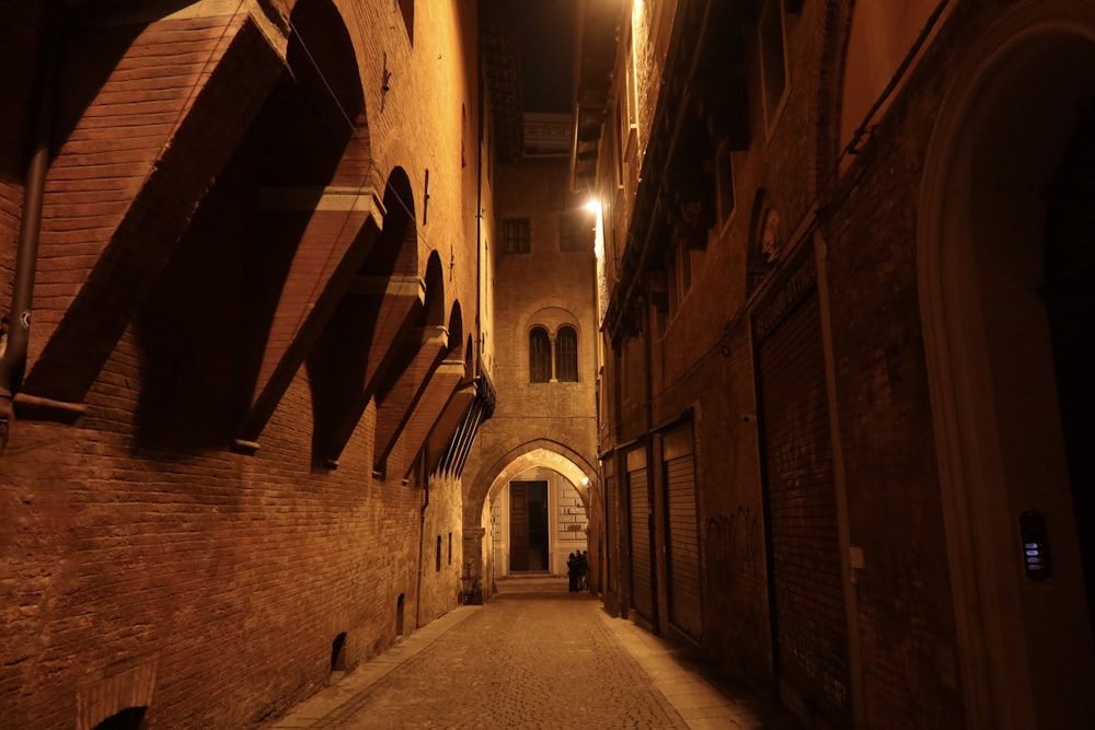 Un callejón estrecho con una torre del reloj al fondo