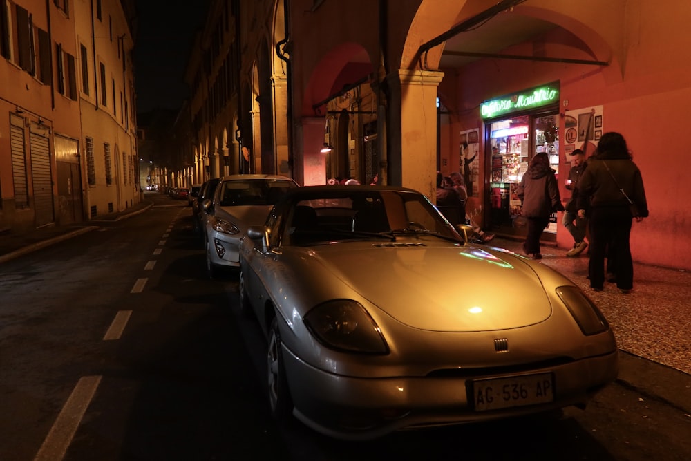 a car parked on the side of a street at night