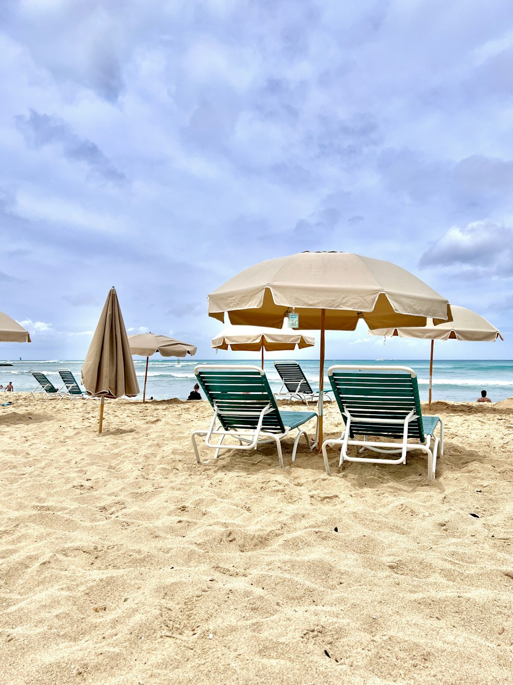 a sandy beach with lawn chairs and umbrellas