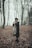a woman standing in the woods in the snow