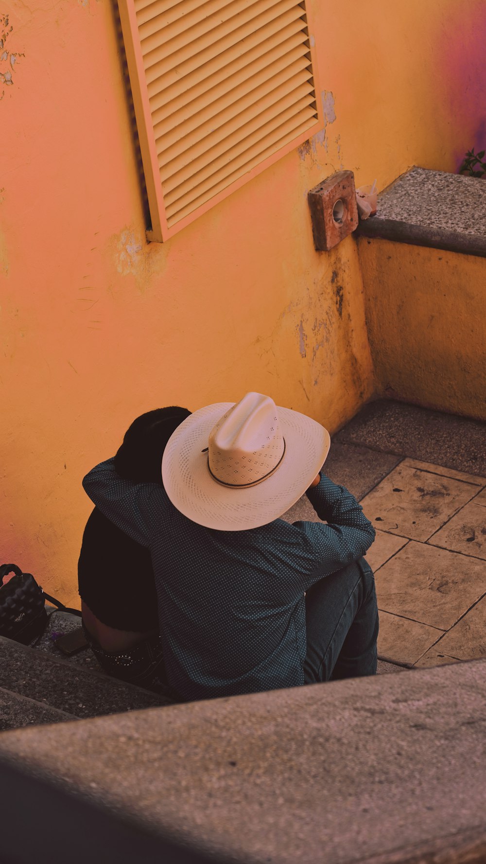 a person sitting on the ground with a hat on