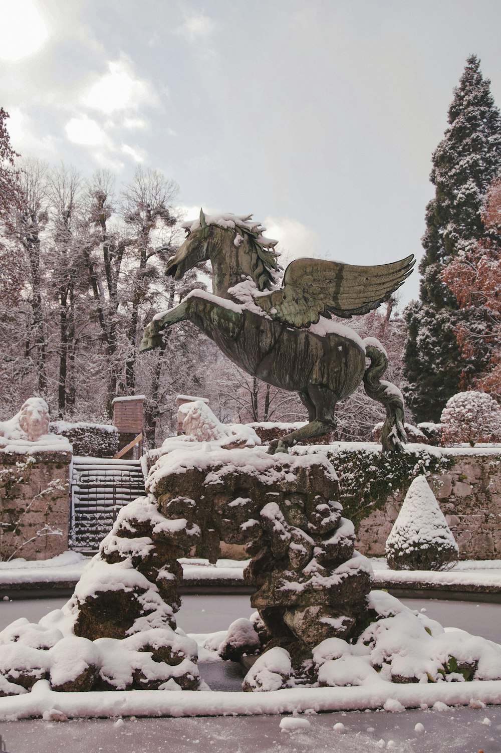 a statue of a horse in a snowy park